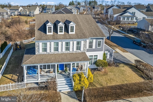 shingle-style home featuring fence, a residential view, and roof with shingles