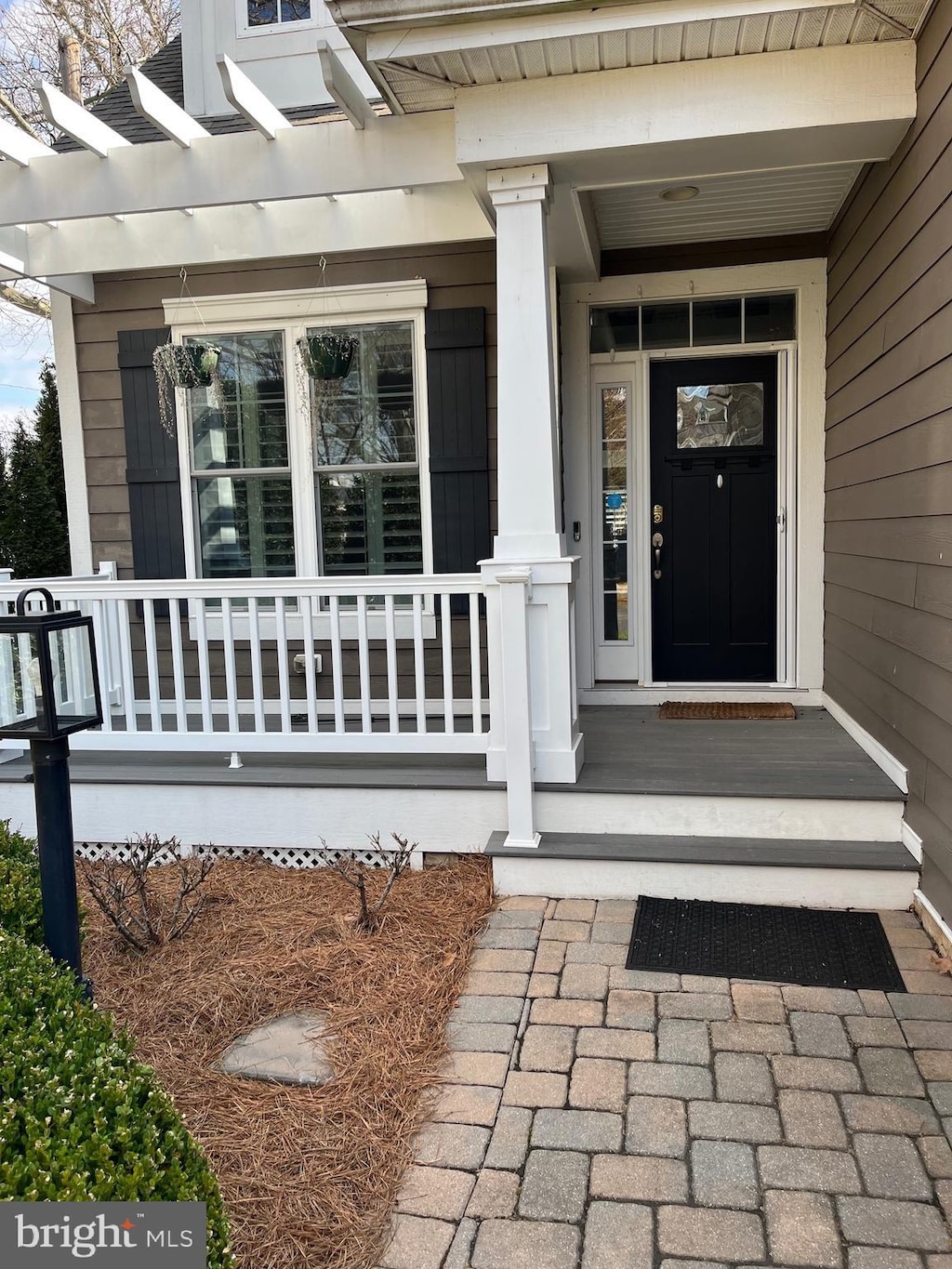 view of exterior entry with a pergola and covered porch