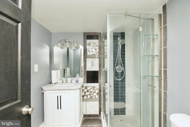 bathroom featuring vanity, toilet, and a stall shower