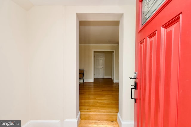 foyer entrance with light wood-style flooring and baseboards