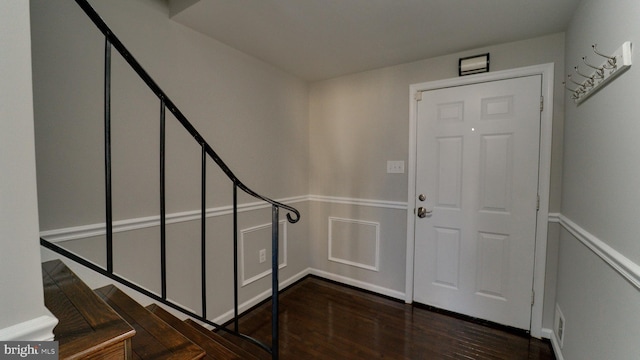 foyer with dark wood-style floors and visible vents