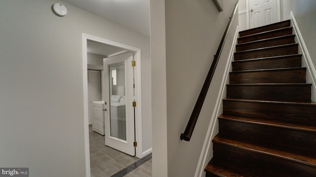 stairway with tile patterned flooring and washer / clothes dryer