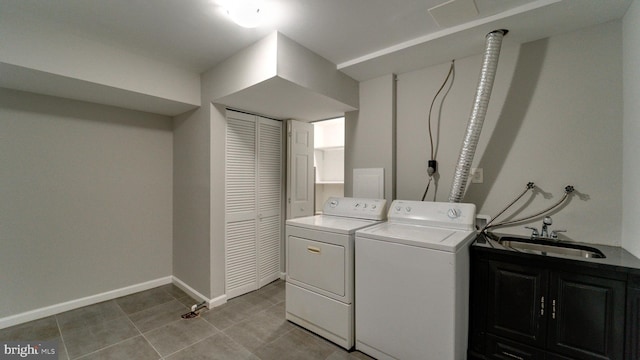 laundry room featuring baseboards, light tile patterned flooring, cabinet space, a sink, and washer and dryer