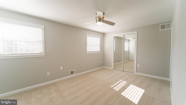 unfurnished bedroom featuring visible vents, baseboards, and light colored carpet