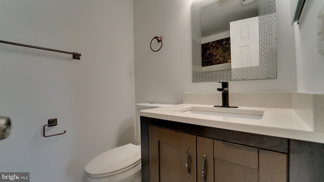 bathroom featuring vanity, toilet, and visible vents