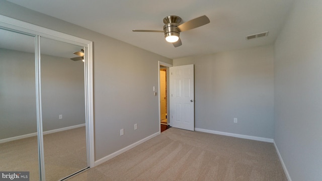 unfurnished bedroom featuring baseboards, visible vents, carpet floors, and ceiling fan