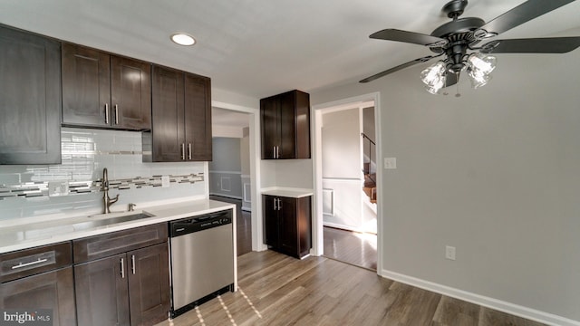 kitchen featuring a sink, dark brown cabinets, stainless steel dishwasher, tasteful backsplash, and light wood-type flooring