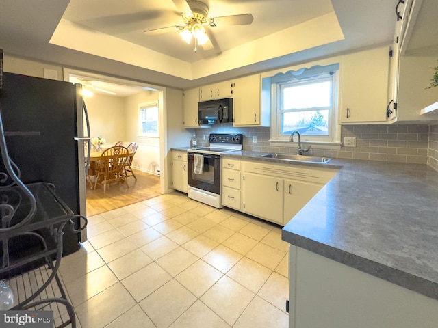 kitchen with black microwave, a raised ceiling, a sink, and electric range oven