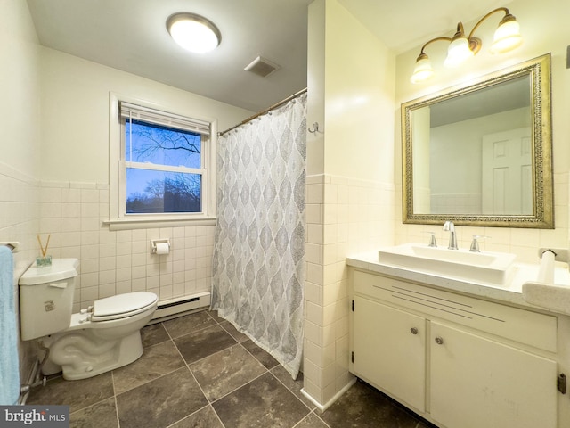 full bath featuring visible vents, toilet, a baseboard radiator, vanity, and tile walls