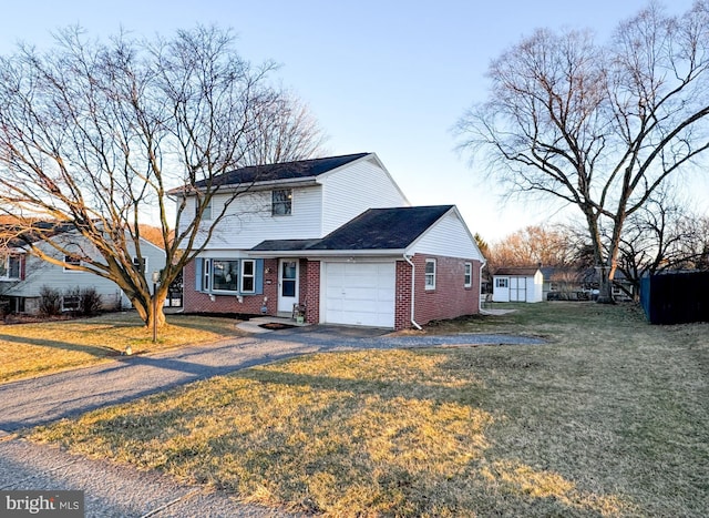 traditional-style home with aphalt driveway, a front yard, brick siding, and an attached garage