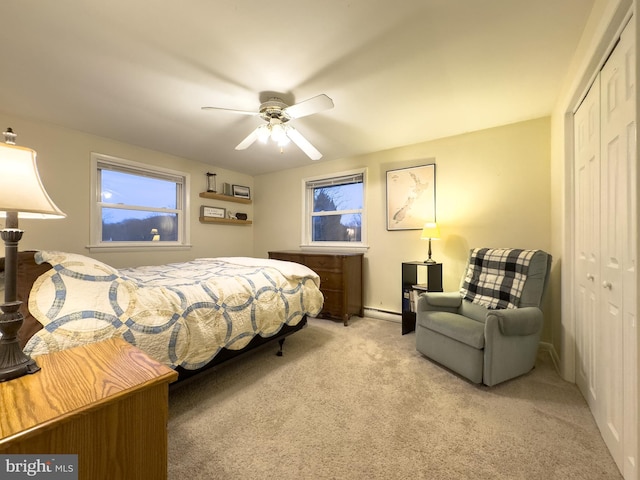 bedroom with ceiling fan, baseboard heating, a closet, and carpet