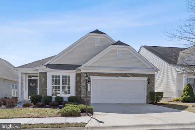 view of front facade with stone siding, an attached garage, and driveway