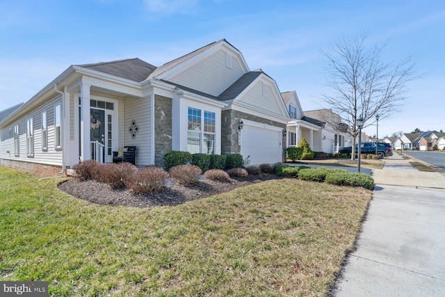 view of front of property with a front yard, a garage, stone siding, and a residential view