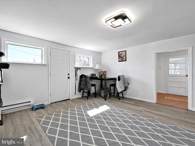 office with a baseboard radiator, baseboards, and wood finished floors