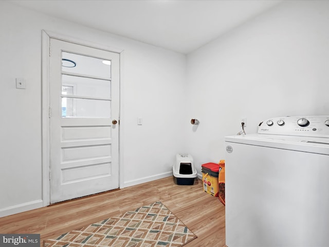 laundry area featuring laundry area, light wood-style flooring, washer / dryer, and baseboards