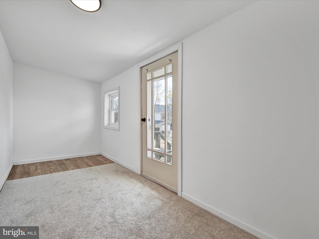 carpeted spare room featuring baseboards