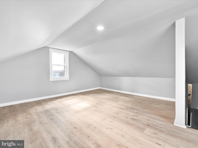 additional living space with lofted ceiling, wood finished floors, and baseboards