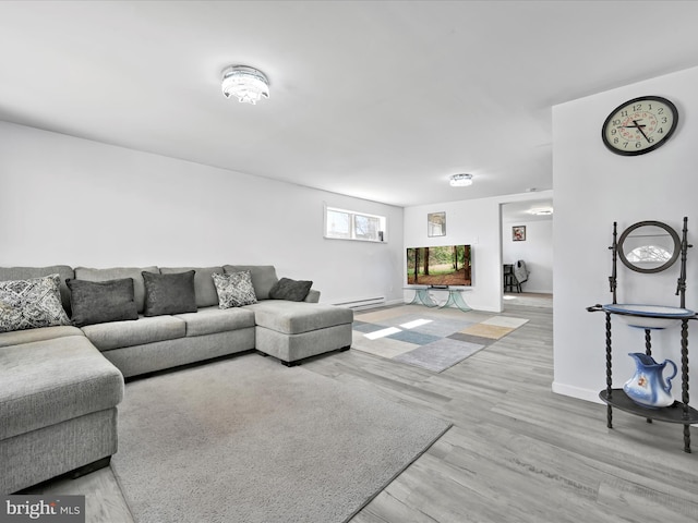 living room with a baseboard heating unit, wood finished floors, and baseboards