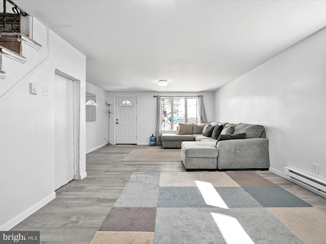 living area featuring a baseboard radiator, baseboards, and wood finished floors