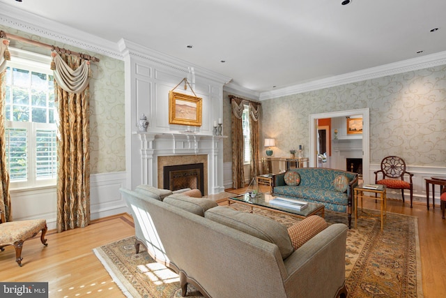 living room with wainscoting, wallpapered walls, and a premium fireplace