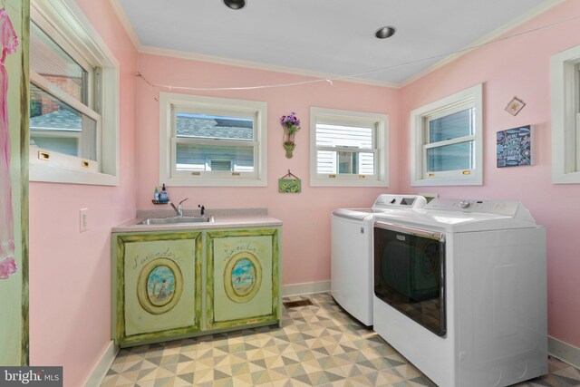 laundry area with washing machine and clothes dryer, baseboards, ornamental molding, laundry area, and a sink