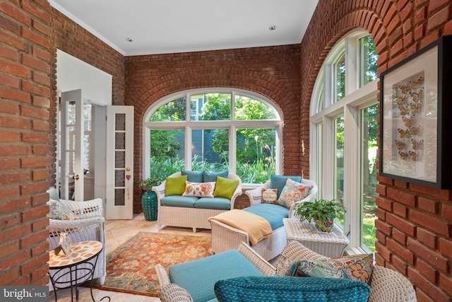 living room with a healthy amount of sunlight and brick wall