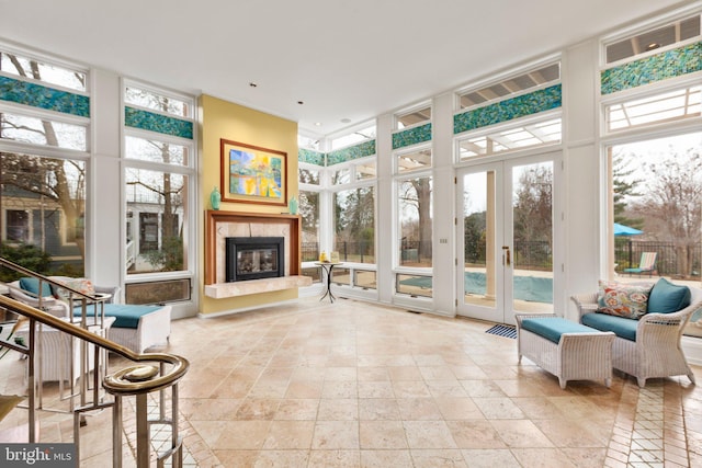 sunroom with a glass covered fireplace and french doors