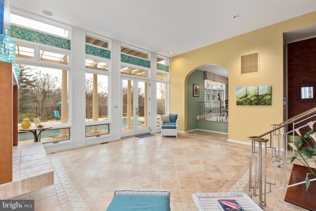 interior space featuring baseboards, arched walkways, and visible vents