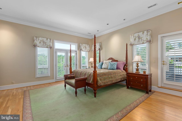 bedroom featuring visible vents, light wood-style flooring, ornamental molding, and access to outside