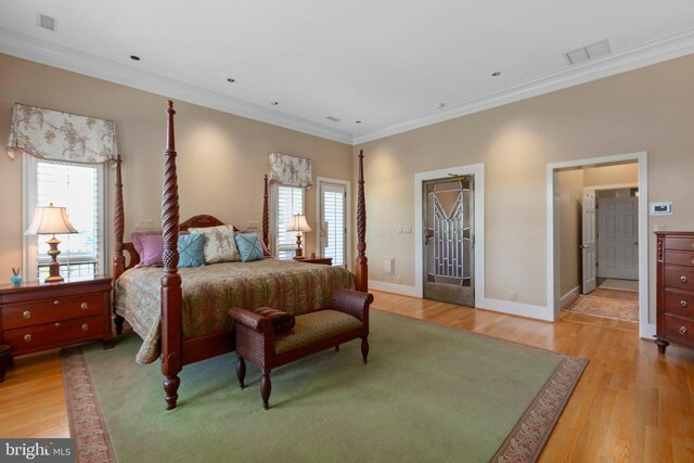 bedroom featuring visible vents, baseboards, light wood-style floors, and crown molding