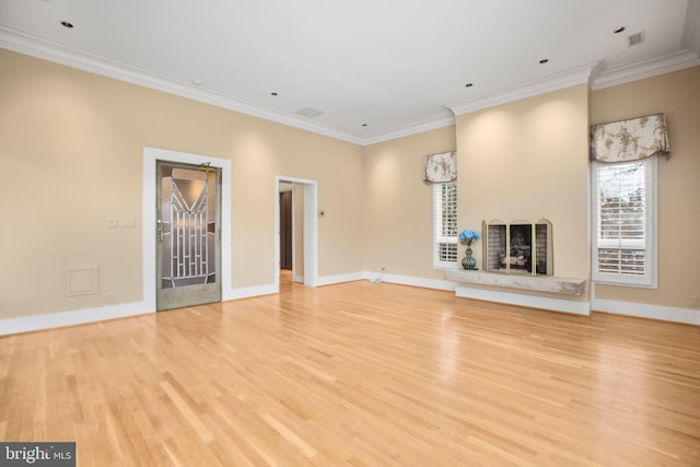 unfurnished living room with light wood-style flooring, baseboards, and ornamental molding