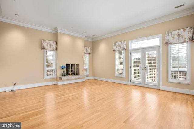 unfurnished living room with visible vents, baseboards, crown molding, and light wood-style floors