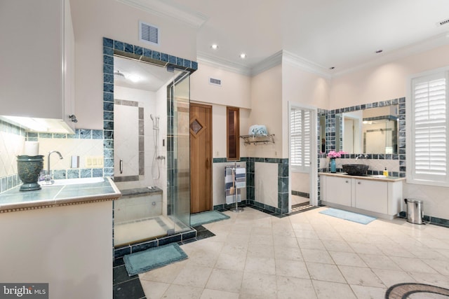 full bath featuring visible vents, two vanities, a shower stall, and crown molding