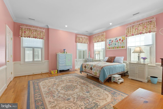 bedroom with visible vents, wood finished floors, and crown molding