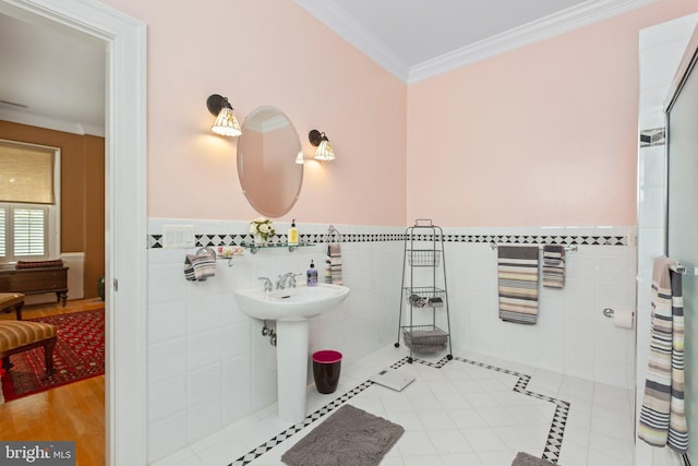 bathroom with walk in shower, a wainscoted wall, ornamental molding, tile patterned floors, and tile walls