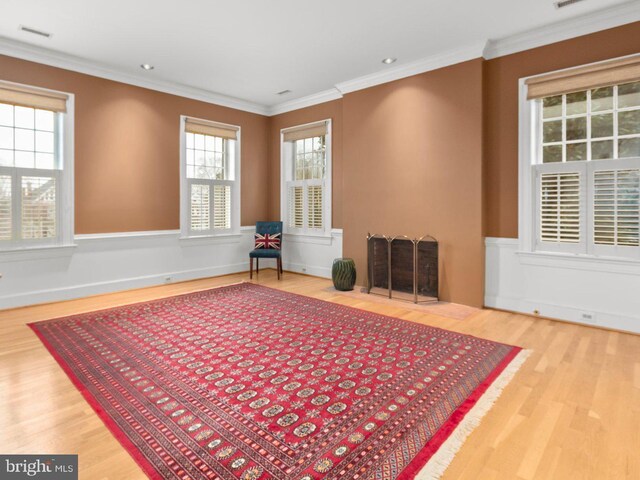 sitting room featuring visible vents, crown molding, and wood finished floors