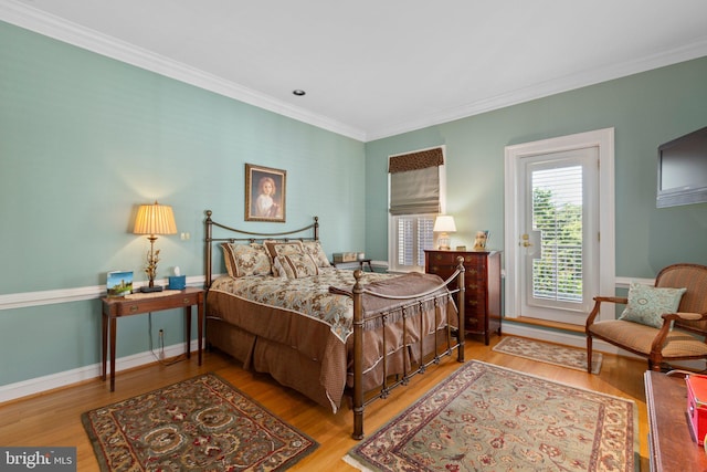 bedroom with baseboards, wood finished floors, and ornamental molding