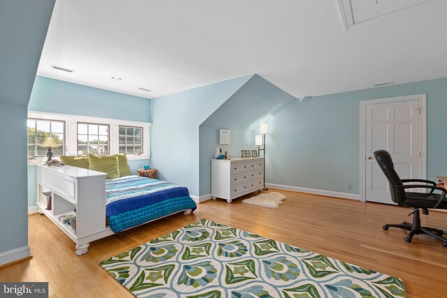 bedroom featuring visible vents, baseboards, and wood finished floors