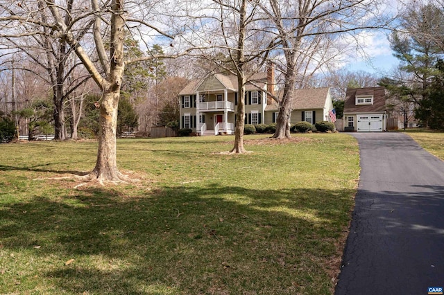 view of front of house with a garage, a front yard, and a balcony