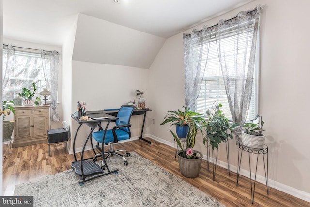 office space with baseboards, wood finished floors, and vaulted ceiling