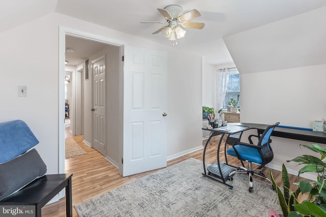 office area with baseboards, light wood-style floors, lofted ceiling, and a ceiling fan