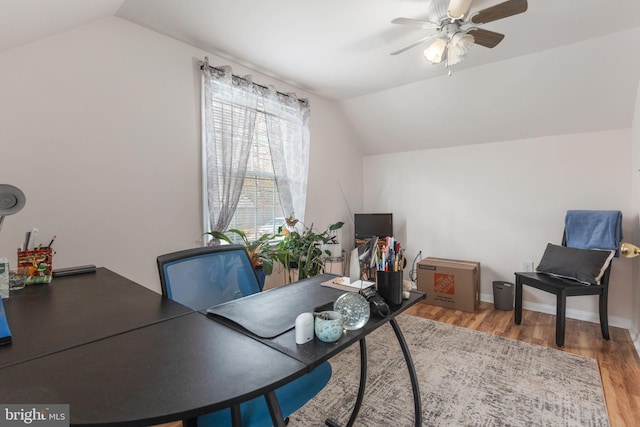 office area featuring baseboards, wood finished floors, a ceiling fan, and vaulted ceiling