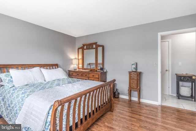 bedroom with wood finished floors and baseboards