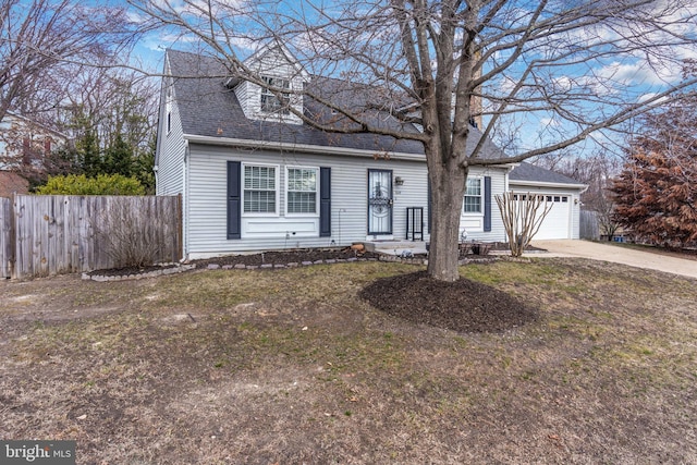 cape cod-style house with driveway, roof with shingles, a garage, and fence