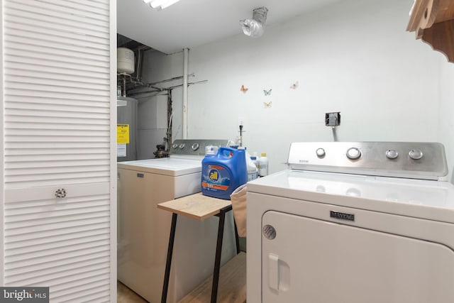 laundry room with water heater, laundry area, and washer and clothes dryer