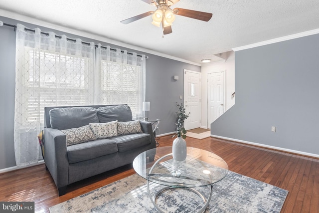 living area with a textured ceiling, baseboards, and wood-type flooring