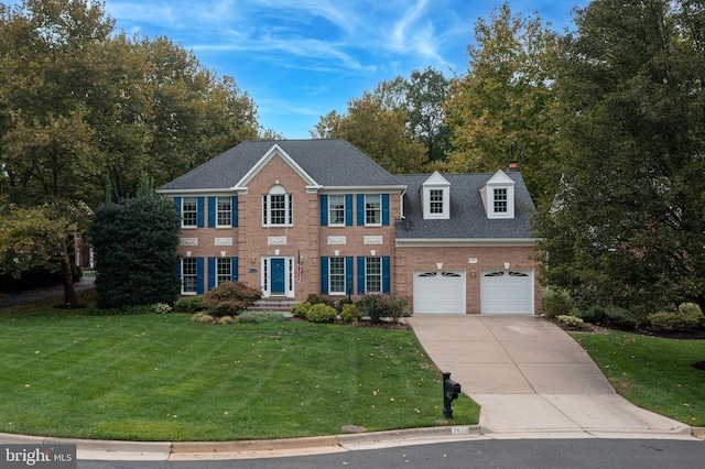 view of front of home with a front yard, a shingled roof, concrete driveway, a garage, and brick siding