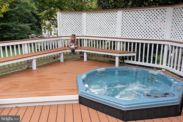 wooden terrace featuring hot tub deck surround