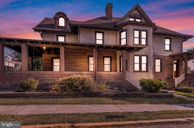 view of front of home featuring a chimney and stucco siding