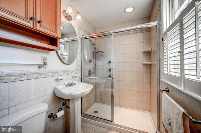 bathroom with a healthy amount of sunlight, a stall shower, and toilet